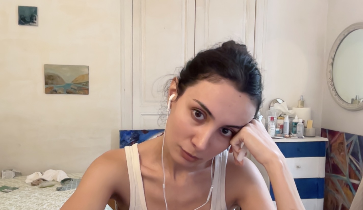 Luiza at home, head resting on her hand, looking into the camera